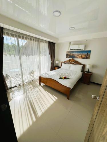 a bedroom with a bed and a large window at Apartment Mai Khao Beach in Mai Khao Beach