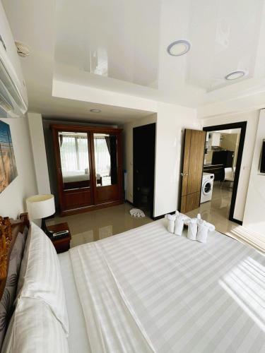 a bedroom with a large bed with white sheets and pillows at Apartment Mai Khao Beach in Mai Khao Beach