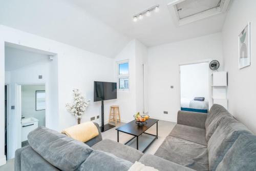a living room with a couch and a tv at New 3BED Stylish Apartment with Amazing Transport in London