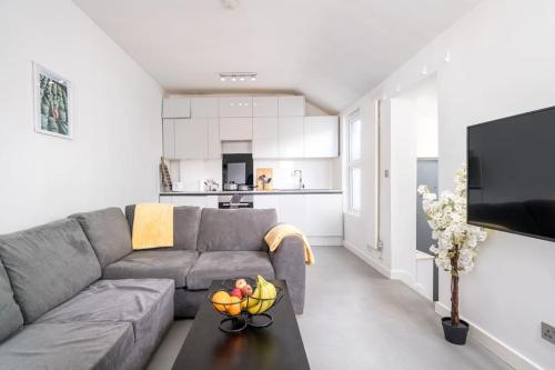 a living room with a gray couch and a table at New 3BED Stylish Apartment with Amazing Transport in London
