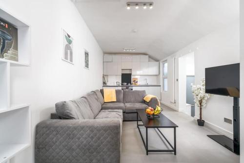 a living room with a gray couch and a table at New 3BED Stylish Apartment with Amazing Transport in London