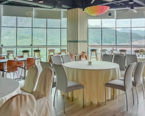 a room with tables and chairs and a large window at Hotel Langkasuka Langkawi in Kuah