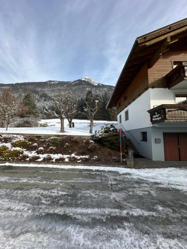 a house with snow on the ground next to a building at Appartements Spitzegel in Hermagor