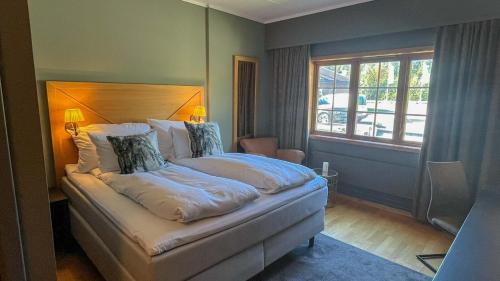 a bedroom with a bed and a large window at Trysil-Knut Hotel in Trysil