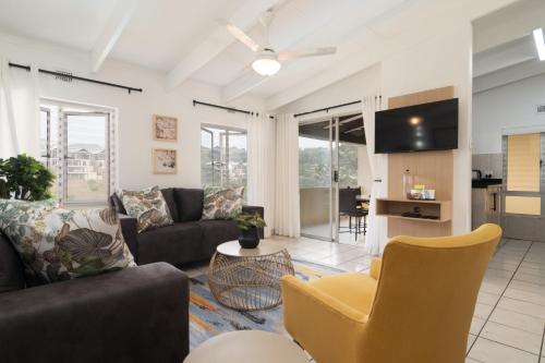 un soggiorno con un divano e un tavolo di Chakas Rock Chalets 49 a Ballito