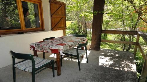 - une table et des chaises sur une terrasse couverte avec une fenêtre dans l'établissement Chalet familial 10 à 12 places dans le Val d'Allos, à Villars-Colmars