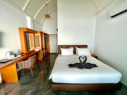a hotel room with a bed with a bow on it at KaiBaeBeach GrandView in Trat