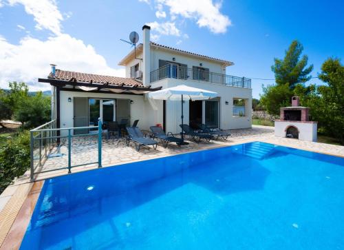 a villa with a swimming pool in front of a house at Villa Eudora in Tsoukaladhes