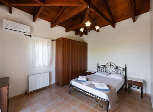 a bedroom with a bed and a wooden ceiling at Villa Eudora in Tsoukaladhes