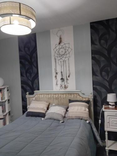 une chambre avec un lit avec des oreillers dessus dans l'établissement Les Merles, à Marcollin