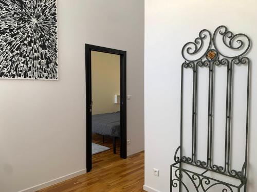 a hallway with a gate and a painting on the wall at Les Fabuleux appartements du Coeur de ville - Place Victor Hugo in Besançon