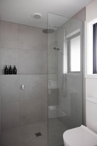 a bathroom with a glass shower with a toilet at The Corner on Te Mata in Havelock North