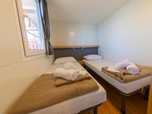 two beds in a room with towels on them at Adria Family Zone B 61 in Klenovica