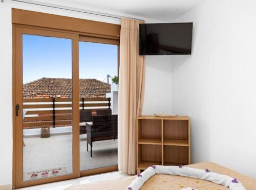 a bedroom with a sliding glass door to a balcony at VaStekaHouse in Haraki