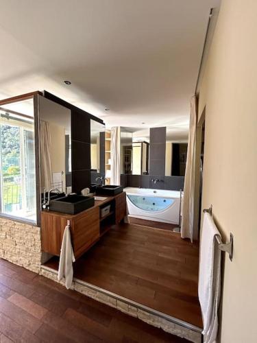 une grande salle de bain avec une baignoire et un grand miroir dans l'établissement Maison provençale 3 chambres, à Cagnes-sur-Mer