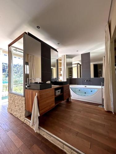 une grande salle de bain avec une baignoire et un grand miroir dans l'établissement Maison provençale 3 chambres, à Cagnes-sur-Mer