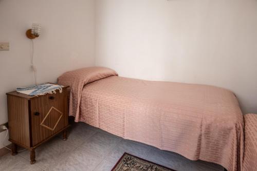 a small bedroom with a bed and a night stand at Casa della nonna in Sperlinga