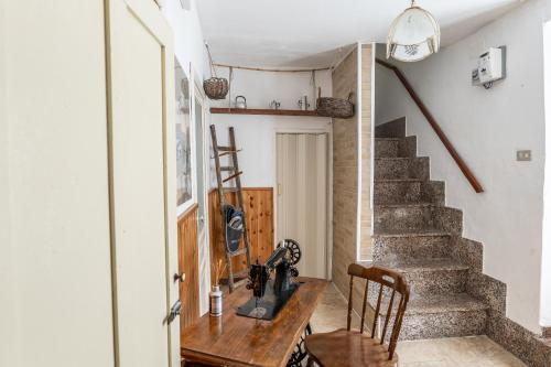 a home office with a wooden table and stairs at Casa della nonna in Sperlinga