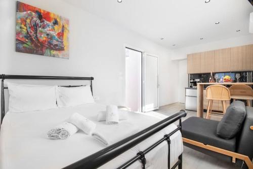 a bedroom with a bed and a chair and a kitchen at Elegant Suite near Beach 6 in Ayía Marína