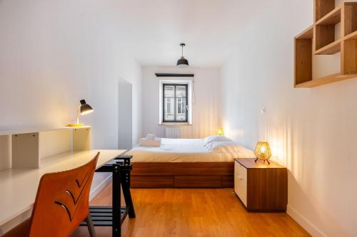 une chambre avec un lit et un bureau avec un bureau dans l'établissement Le carré de Nicolas, à Nancy