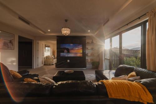 a living room with a couch and a flat screen tv at Sunlit Sanctuary with Private Patio in Wigram in Christchurch