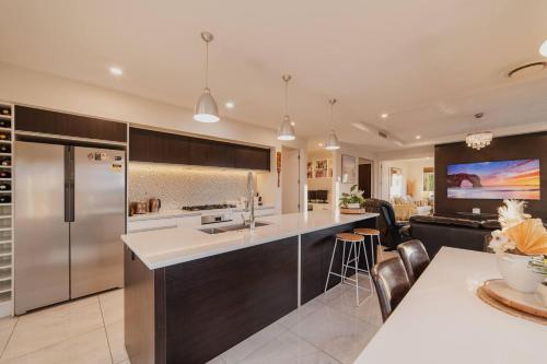 a kitchen with stainless steel appliances and a living room at Sunlit Sanctuary with Private Patio in Wigram in Christchurch