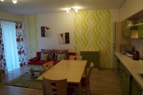 a kitchen and living room with a table and a couch at Apartments Klinovec in Loučná pod Klínovcem