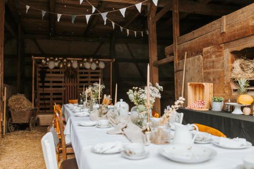 a long table with white plates and vases on it at Familienhof Waida in Dennheritz