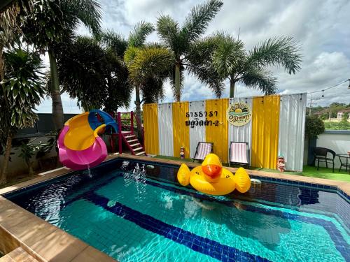 a swimming pool with two rubber ducks in the water at Dream pool villa 2 in Ban Nong Chap Tao