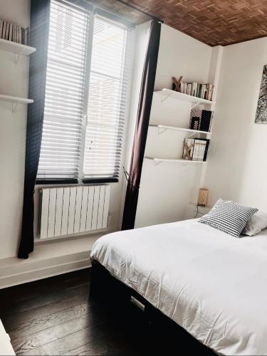 une chambre avec un lit et une fenêtre dans l'établissement Appartement d'Architecte chic et élegant, à Paris