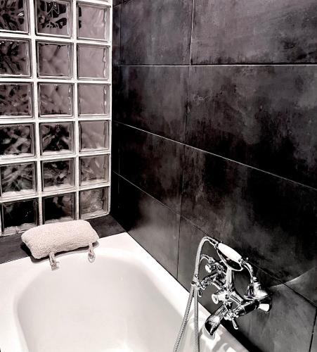 une baignoire avec deux robinets dans une salle de bain dans l'établissement Appartement d'Architecte chic et élegant, à Paris