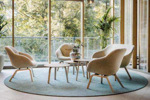 a room with three chairs and a table and a window at Heilthermen Resort Bad Waltersdorf in Bad Waltersdorf