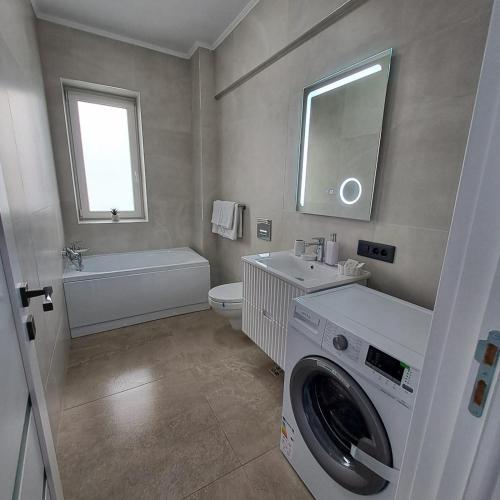 a bathroom with a washing machine and a sink at Vily Apartment in Focşani