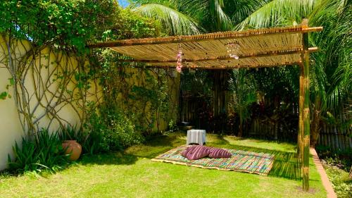 a garden with a pergola and a table on the grass at TLT Guesthouses - Dauin in Dauin