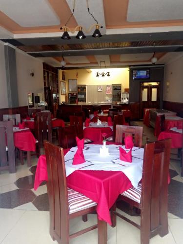a restaurant with red tables and chairs with red napkins at Hotel Winstar in Eldoret