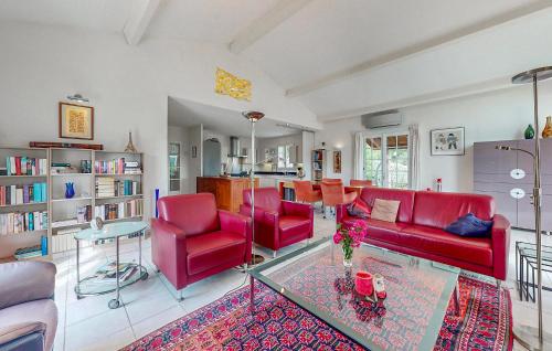 - un salon avec des chaises rouges et une table en verre dans l'établissement 3 Bedroom Stunning Home In Ecuras, à Écuras