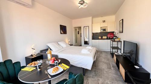 une chambre avec un lit et une table et une cuisine dans l'établissement Ze Perfect Place - Studio centre-ville - Masséna, à Nice