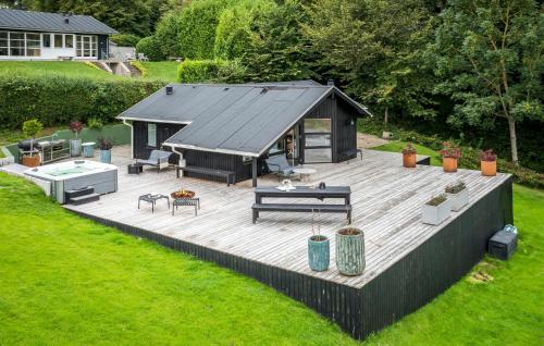 a large wooden deck with a black roof at Beautiful Home In Kolding With Wifi in Kolding