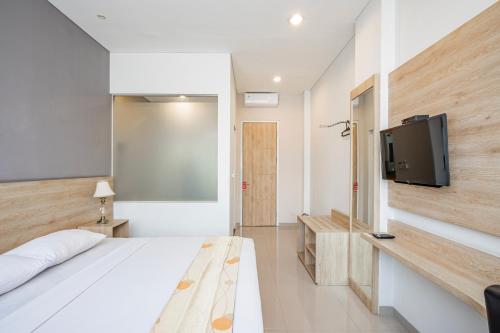 a bedroom with a bed and a flat screen tv at Hotel Pesona Ciwidey in Ciwidey