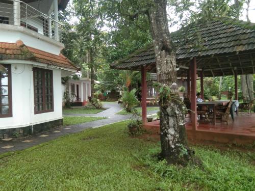 a house with a gazebo and a tree at Lovedale Lakeside Homestay in Alleppey