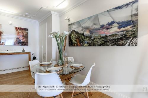 a dining room with a glass table and white chairs at Au 30 Lille Centre Grand Palais in Lille