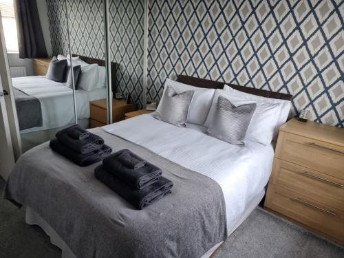 クラムリントンにあるThe Humsford Hideaway 2 bedroom home with drivewayのベッドとタオル2枚のある寝室