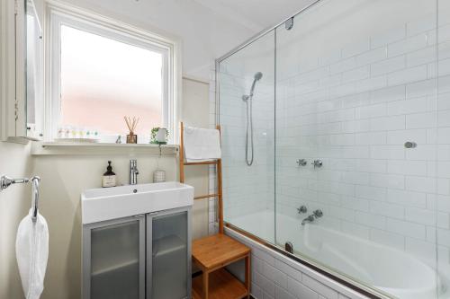Un baño con ducha, lavabo y bañera. en Cute Retro Gem, en Geelong
