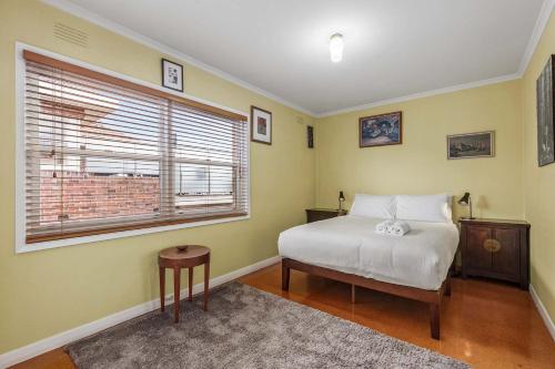 Un dormitorio con una cama y una ventana en Cute Retro Gem, en Geelong