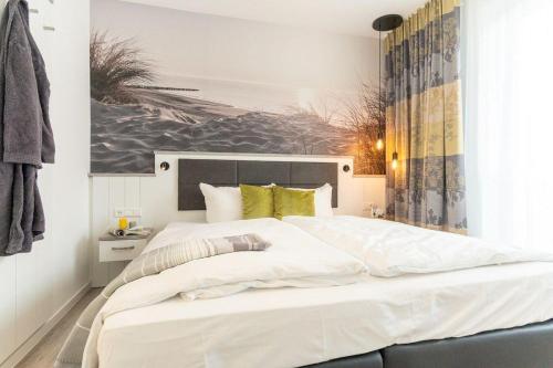 a bedroom with a large white bed with yellow pillows at Haus-Meerblick-Villa-Wohnung-17-Hygge in Großenbrode