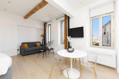 un salon blanc avec une table et un canapé dans l'établissement Appartement 33 m2 comme une junior suite - vue Port et Palais des festivals, à Cannes