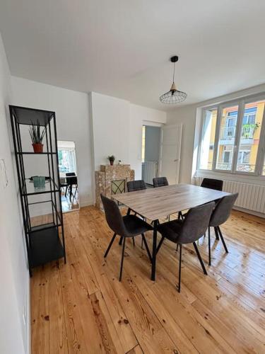 une salle à manger avec une table et des chaises en bois dans l'établissement Appartement T2 idéalement situé, au Puy-en-Velay