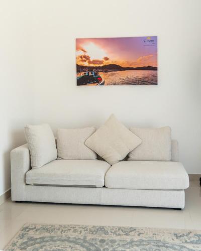 a white couch in a living room with a painting at 3BR villa and maid room by escape time in Sharm