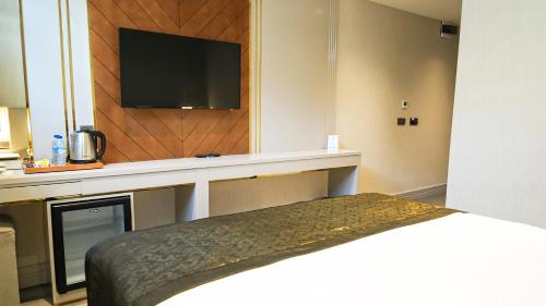 a hotel room with a bed and a flat screen tv at Sky Hill Hotel in Ankara