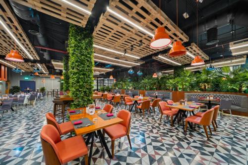 a restaurant with tables and chairs and plants at Park Regis Business Bay in Dubai